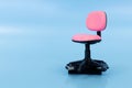 Close-up of a miniature pink office chair with a USB flash drive inserted into its base on a solid blue background Royalty Free Stock Photo