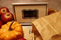 Close up on a miniature pumpkin and crispbread lying in front of a framed blank chalkboard sign