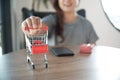 Close up of miniature shopping cart /trolley toy figure. smart phone and red gift box on table for shopping and e-commerce concept Royalty Free Stock Photo