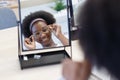 Close up mirror with face of young woman African American afro hair wear spectacles. Choosing eyeglasses used correct or assist Royalty Free Stock Photo