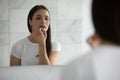 Close up mirror reflection young woman applying lipstick