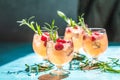 Close up mix berries ice soda with thyme in a transparent glass on white table at cafe