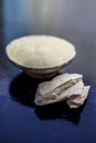 Close up of mixed multani mitti or mulpani mitti or fuller`s earth in a clay bowl on wooden surface along with raw clay from Royalty Free Stock Photo