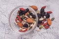 Close up of a Mixed of Nuts, Dry Fruits in glass Bowl on Gray Textured Background. top view. Royalty Free Stock Photo