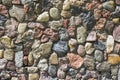 Close up of mixed pebbles texture. Pebble stones stacked into a wall on a sunny day Royalty Free Stock Photo