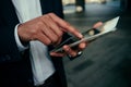 Close up mixed race businessman typing on digital tablet standing outside work office