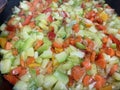 close up of a mixture of chopped vegetables frying in olive oil in a frying pan, zucchini, carrot, leek and peppers, selective Royalty Free Stock Photo