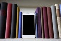 Close up of mobile phone in bookshelf