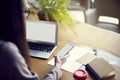 Close-up of mobile phone screen and laptop while at wooden tabl Royalty Free Stock Photo