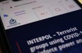 Close up of mobile phone with website of interpol with warning about covid-19 terrorists