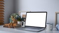 Mock up computer laptop, coffee cup and office supplies on white table. Royalty Free Stock Photo