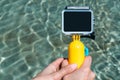 Close-up, Mockup of an action camera with a yellow float. against the backdrop of a pool of water