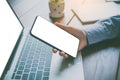 Close-up mockup image of  hand holding black mobile phone with blank white  in desk work for home Royalty Free Stock Photo