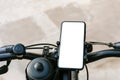 Close-up, mockup of a smartphone on the handlebars of a bicycle. Against the background of concrete and asphalt