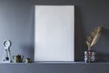 Close-up of mockup of white empty poster in grey flat interior w