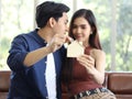 House model in couple`s hands , woman hold house model while her boyfriend putting coin into house model,selective focus on house Royalty Free Stock Photo