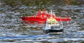 Close up of a model Pilot Boat - Spitfire - on the water with red model boat in background - Warminster, Wiltshire, UK