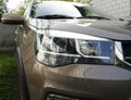 Close-up of modern automotive LED headlights in the open air on a brown car from a Chinese manufacturer