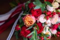 Close up of modern a beautiful and stylish wedding bouquet of red, pink roses and eucalyptus greenery on wooden background. Royalty Free Stock Photo