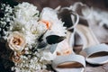 Close up of modern a beautiful, stylish wedding bouquet of white, yellow roses, female shoes and eucalyptus greenery. Royalty Free Stock Photo