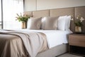 close-up of a modern bed with beige linens in a furnished bedroom