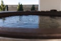 Close-up of modern big hot tub outdoor. Clear water in iron tube. Relaxation on holidays Royalty Free Stock Photo