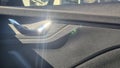 Close-up of modern car door interior showcasing sleek handle and textured panel with sunlight reflecting, emphasizing de Royalty Free Stock Photo