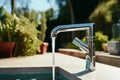 Close-up of modern chrome kitchen faucet with running water, acrylic stone countertop, stainless steel built-in sink Royalty Free Stock Photo