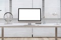 Close up of modern creative designer office interior with clean white computer screen, headphones and other items on desktop. Royalty Free Stock Photo