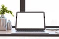 Close up of modern designer office desktop with white mock up computer display, decorative vase with plant, other objects and Royalty Free Stock Photo