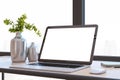 Close up of modern designer office desktop with white mock up computer screen, decorative vase with plant, other objects and Royalty Free Stock Photo