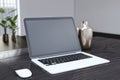 Close up of modern designer office workplace with empty mock up laptop computer screen and other items. Blurry office interior Royalty Free Stock Photo