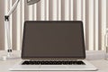 Close up of modern designer office workplace with empty mock up laptop screen and other items. Decorative wall in the background. Royalty Free Stock Photo