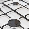 Close-up of a modern gas stove burner with metal grates and control knobs Royalty Free Stock Photo