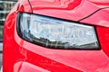 Close-up of modern headlight of new red car