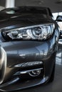 close up of modern headlights on luxury silver new car in automobile salon. Detail grey metallic bumper car with LED Royalty Free Stock Photo