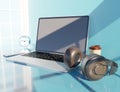 Close up modern headphone with a laptop on a blue desk