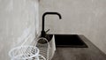 Close-up of a modern kitchen faucet and sink. Black tap on the sink. Farmhouse kitchen sink detail with black faucet Royalty Free Stock Photo