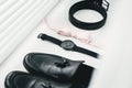 Close up of modern man accessories. beige bow tie, black leather shoes, belt and watch Royalty Free Stock Photo