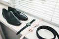 Close up of modern man accessories. beige bow tie, black leather shoes, belt and watch Royalty Free Stock Photo