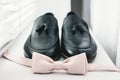 Close up of modern man accessories. beige bow tie, black leather shoes Royalty Free Stock Photo
