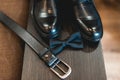 Close up of modern man accessories. Black bow tie, leather shoes and belt