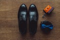 Close up of modern man accessories. Blue bowtie, leather shoes, belt, cufflinks and wedding rings in a orange box Royalty Free Stock Photo