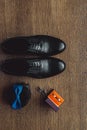 Close up of modern man accessories. Blue bowtie, leather shoes, belt, cufflinks and wedding rings in a orange box Royalty Free Stock Photo