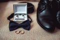 Close up of modern man accessories. wedding rings, black bowtie, leather shoes, belt and cufflinks Royalty Free Stock Photo