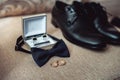 Close up of modern man accessories. wedding rings, black bowtie, leather shoes, belt and cufflinks Royalty Free Stock Photo