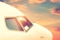 Close-up modern passenger commercial airplane cockpit flying against colorful dramatic sunset sky. Detail side view of Royalty Free Stock Photo
