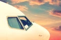 Close-up modern passenger commercial airplane cockpit flying against colorful dramatic sunset sky. Detail side view of Royalty Free Stock Photo