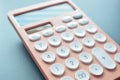 close up modern peach colour pastel calculator and white button on blue background Royalty Free Stock Photo