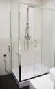 A close-up of a modern rectangular shower enclosure, cubicle, cabin with a shower head and a bidet shower in a black and white